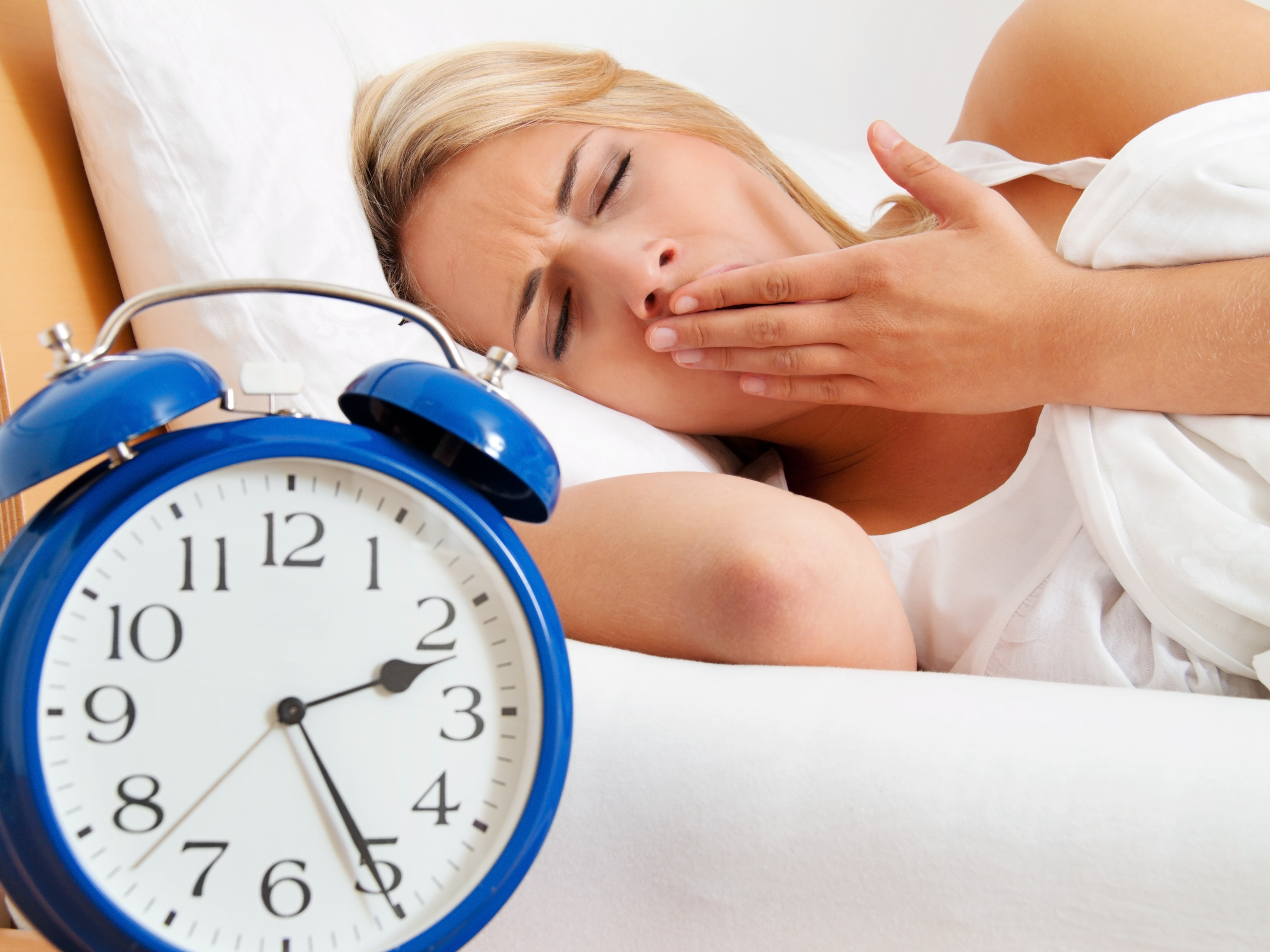 insomnia with clock in the night. woman can not sleep.